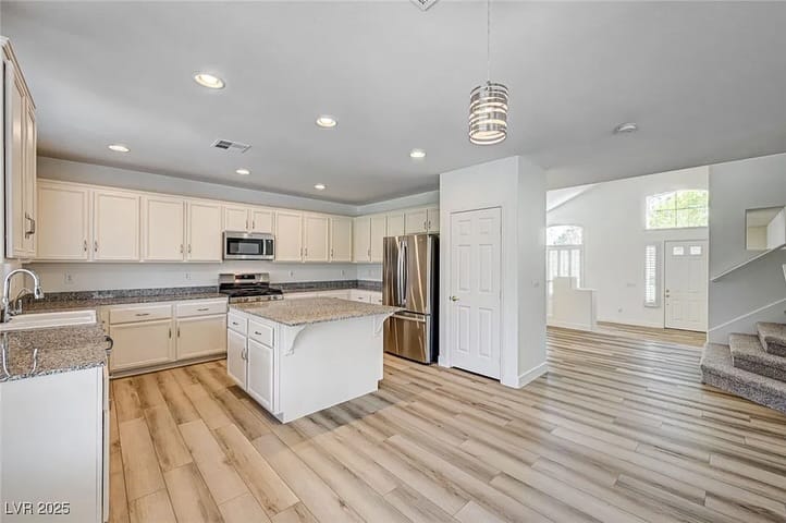 Cocina abierta y escalera en una casa vendida por Park Place Realty, Las Vegas