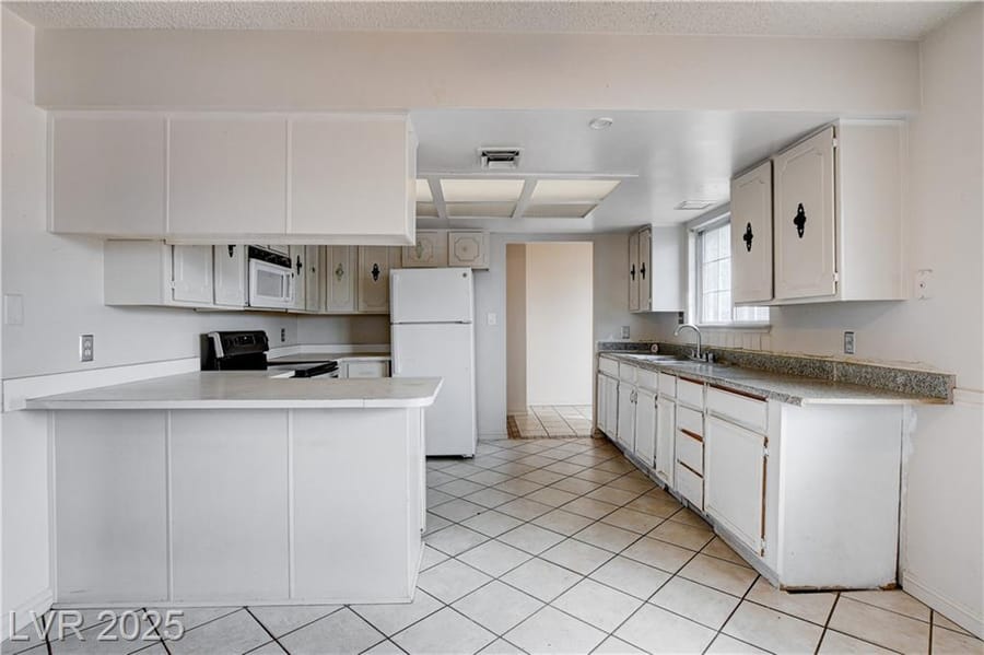 Cocina de primera casa con gabinetes blancos, vendida por Park Place Realty, Las Vegas